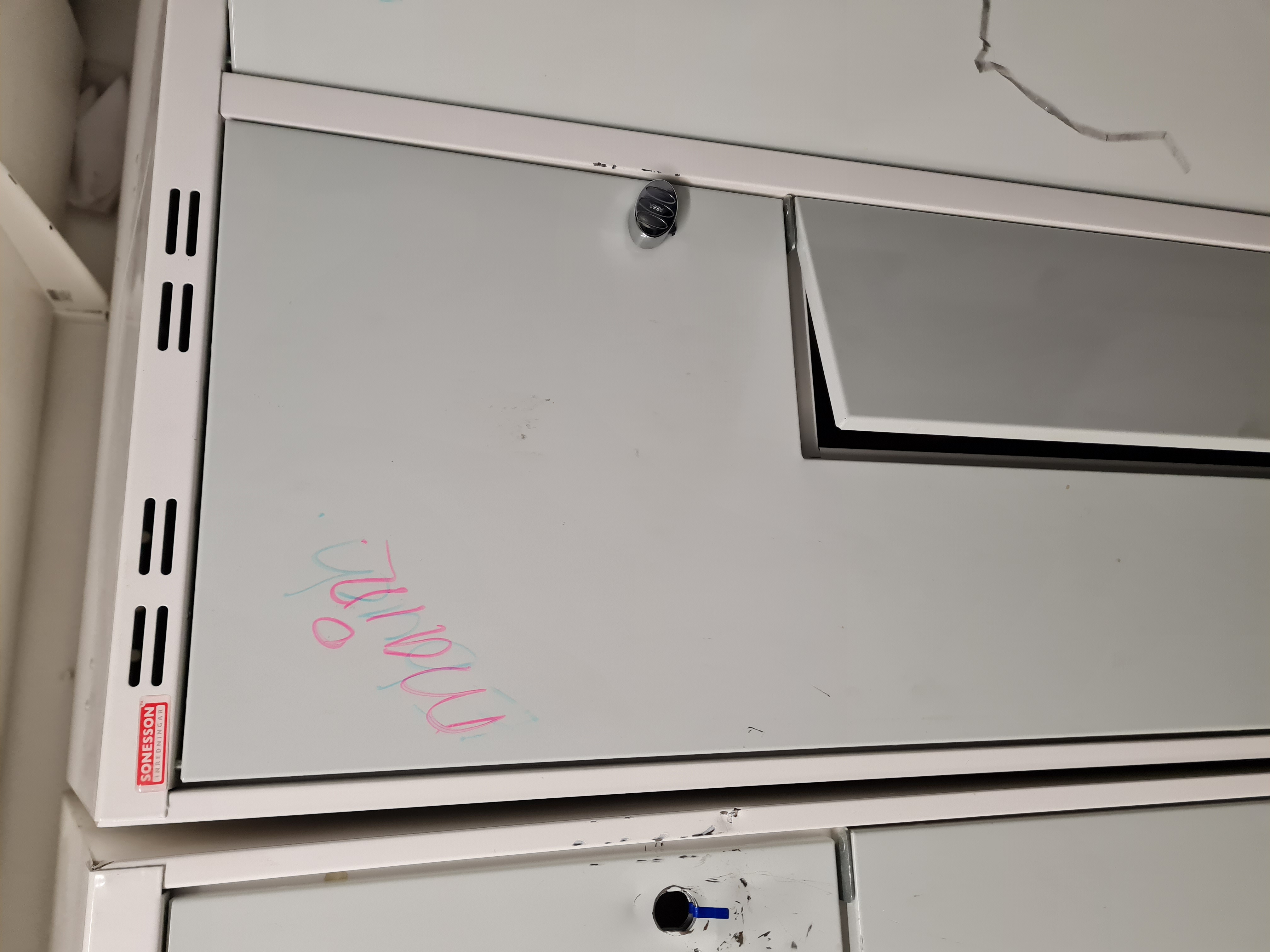 Damaged and half-open locker with name written in marker