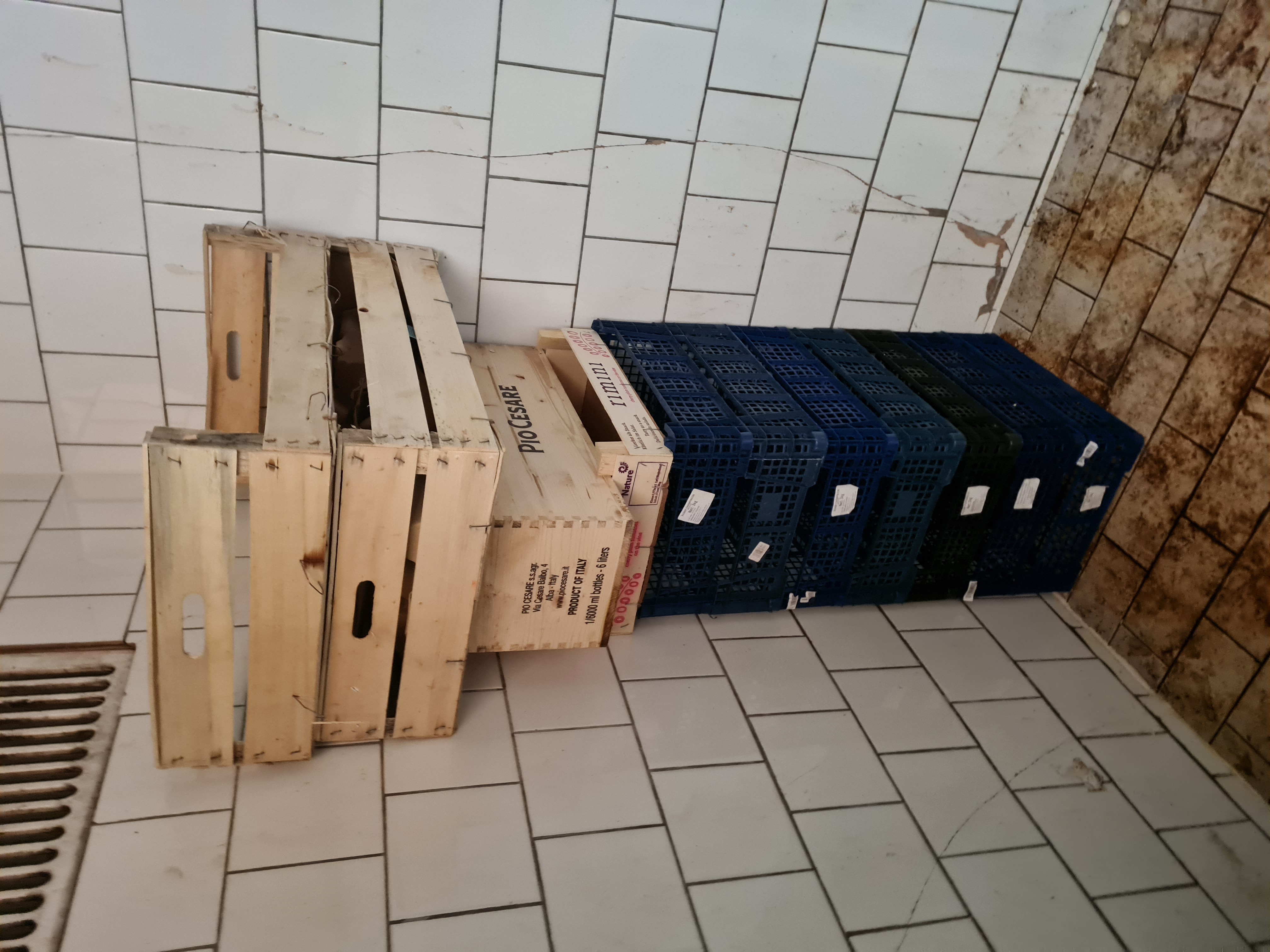 Stacked crates in dirty tiled corner