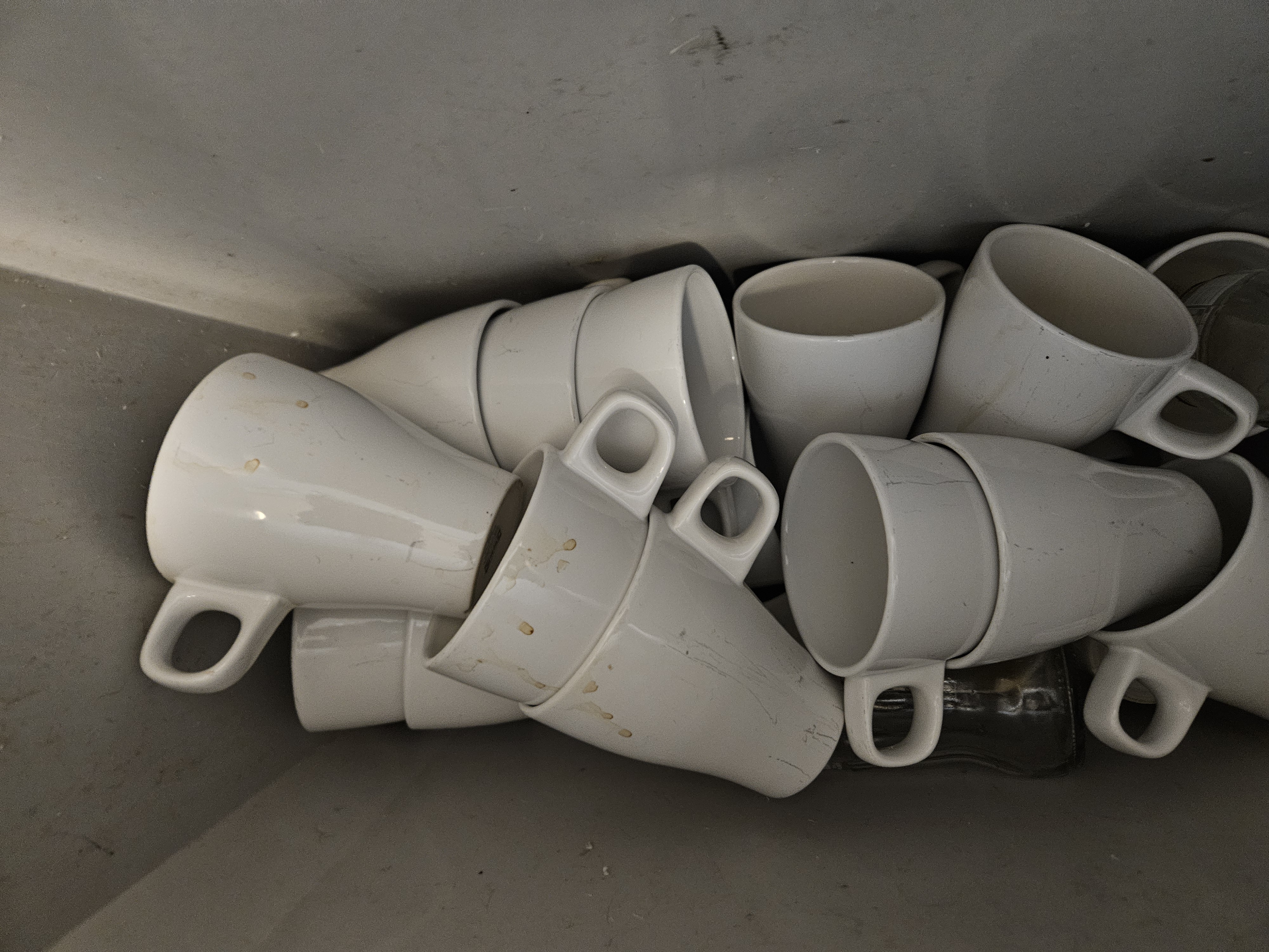 Cartons déchirés, bouteilles vides et déchets au sol derrière un restaurant